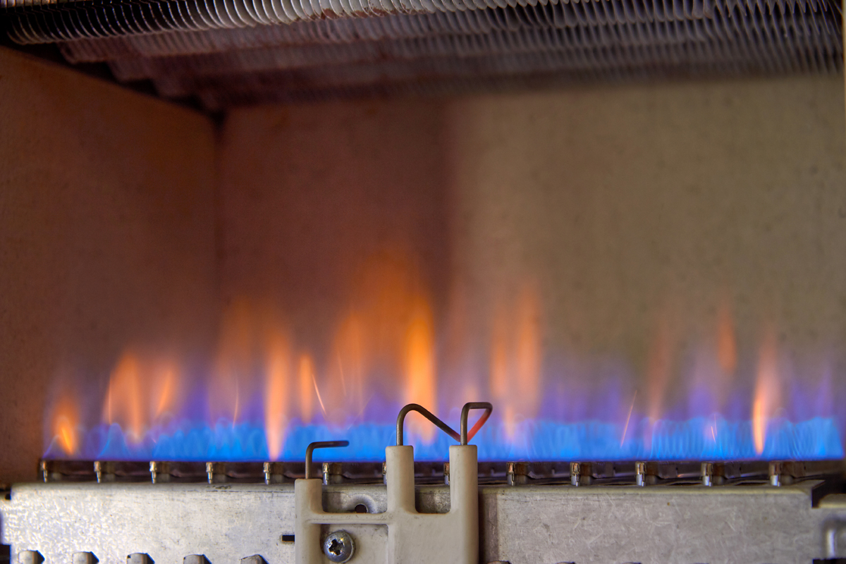 Gas Burning In A Heating Appliance. A Stainless Steel Burner Heats A Copper Heat Exchanger. Gas Burning In A Heating Appliance. A Stainless Steel Burner Heats A Copper Heat Exchanger.