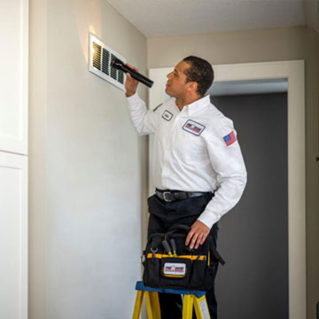 Man Inspecting Air Vent